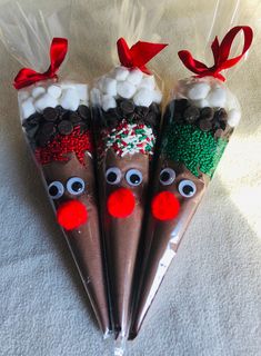 three chocolate covered candy sticks decorated like reindeers