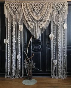 a large white curtain with tassels hanging from it's sides on a wooden floor