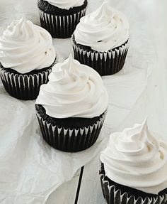 six cupcakes with white frosting on top