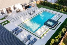 an aerial view of a backyard with a pool and patio furniture in the foreground