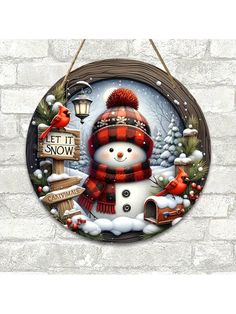 a snowman with a red hat and scarf hanging on a brick wall next to a bird feeder