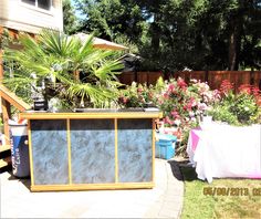 an outdoor garden with flowers and plants in the back yard, next to a wooden fence