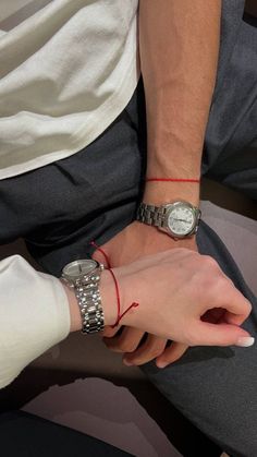 two people wearing wrist watches and bracelets