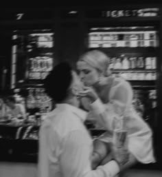 black and white photograph of woman sitting on man's lap in front of store