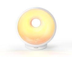 a white alarm clock sitting on top of a wooden stand with an orange light in the middle