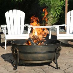 an outdoor fire pit with chairs around it