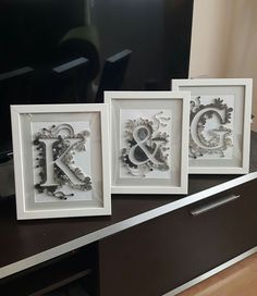 three framed monograms are sitting on a table