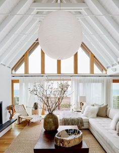 a living room filled with lots of furniture and a large white ball hanging from the ceiling