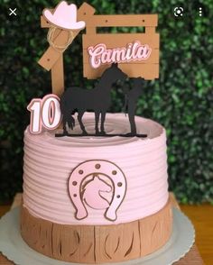 a pink and brown birthday cake with horses on top