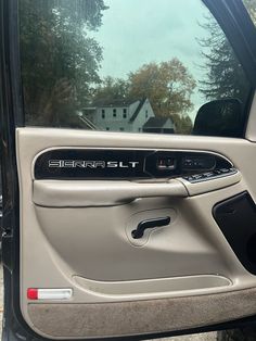 the door handle and driver's side window of a vehicle that is parked in front of a house