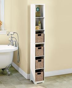 a bath tub sitting next to a tall white shelf with baskets on it's sides