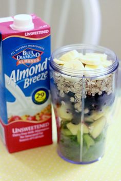 a glass jar filled with fruit and cereal next to a carton of almond milk