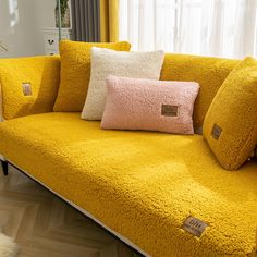 a yellow couch with some pillows on it