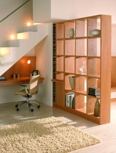 a chair sitting in front of a desk under a stair case next to a plant