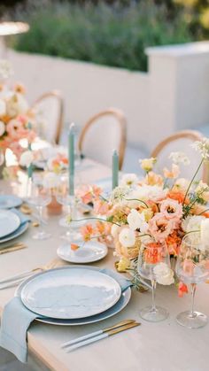 the table is set with flowers and candles on it for an elegant dinner party or wedding reception