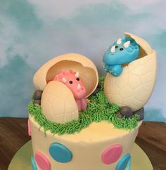 there is a cake decorated with an egg and two dinosaurs