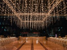 a large room with lights hanging from the ceiling and tables set up for an event