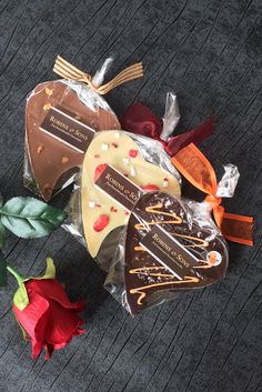 three pieces of cake sitting on top of a table next to a rose and ribbon