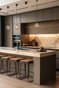 a modern kitchen with marble counter tops and stools