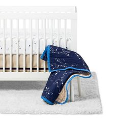 a white crib with a blue blanket on it