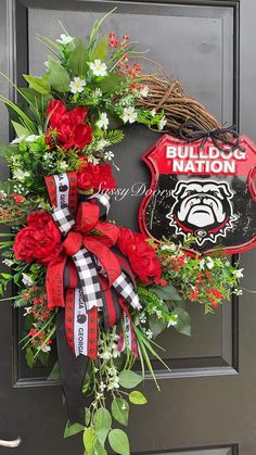 a wreath on the front door is adorned with red flowers and greenery, which reads bulldogs nation