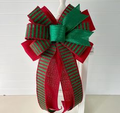 a red and green christmas bow on a chair