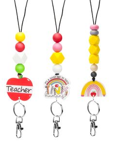 three key chains with different colored beads and charms on each one, the word teacher is written