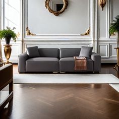 an elegant living room with white walls and wood flooring, large mirror on the wall