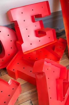 the letters e and f are made out of red plastic pipes, with holes in them