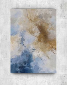 an abstract painting with blue and gold colors on a white wall above a concrete floor