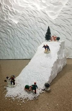 a fake snow covered mountain with toy people on it