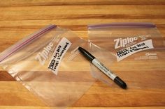 two ziploc bags and a pen on a wooden table with some stickers