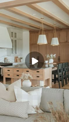 a living room filled with furniture next to a kitchen and dining room table covered in white pillows