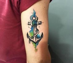 an anchor tattoo on the arm with watercolor paint splatters and dots around it