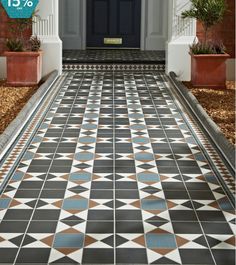 an entry way with tiled floors and potted plants on either side of the door