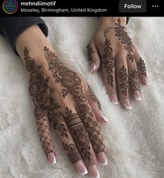 two hands with hendi tattoos on them sitting on a white furnishing area