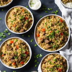 four bowls filled with rice and vegetables on top of a table