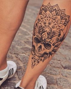 a person's leg with a tattoo on it and a skull in the middle