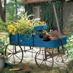 a green wagon filled with lots of flowers