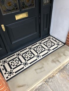 the front door is decorated with black and white tiles