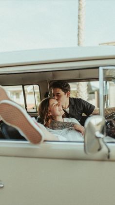 a man and woman are sitting in the back of a car with their feet up