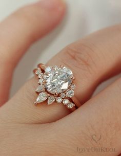 a woman's hand with a diamond ring on top of her finger and an engagement band