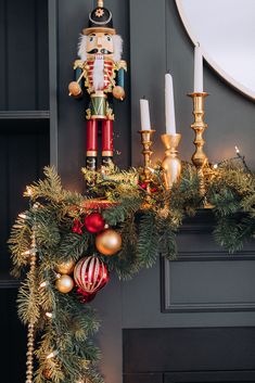 a nutcracker is sitting on top of a mantel decorated with christmas decorations