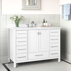 a white bathroom vanity with two sinks and mirrors on the wall above it is tiled flooring