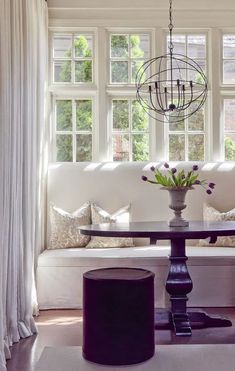 a living room filled with furniture and a chandelier hanging from the ceiling over a white couch