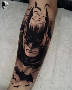 a batman tattoo on the leg of a man