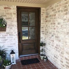 a front porch with potted plants and a door