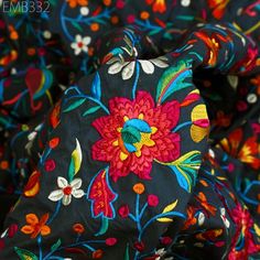 the fabric has colorful flowers on it and is black with red, yellow, blue, green