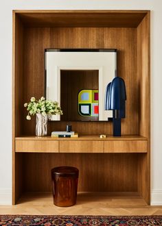 a wooden shelf with a mirror and vase on it