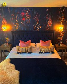 a bed with two pillows on top of it next to night stands and lamps in the background